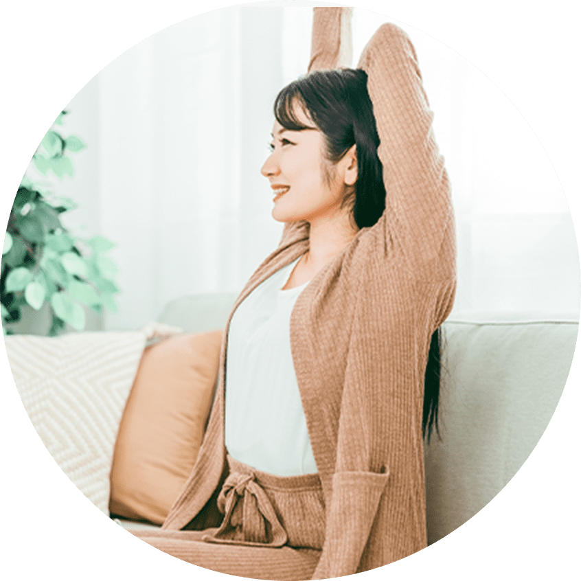 ソファで背伸びをしている女性の写真